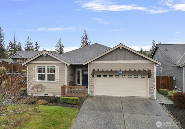 ranch-style home featuring board and batten siding, driveway, an attached garage, and fence