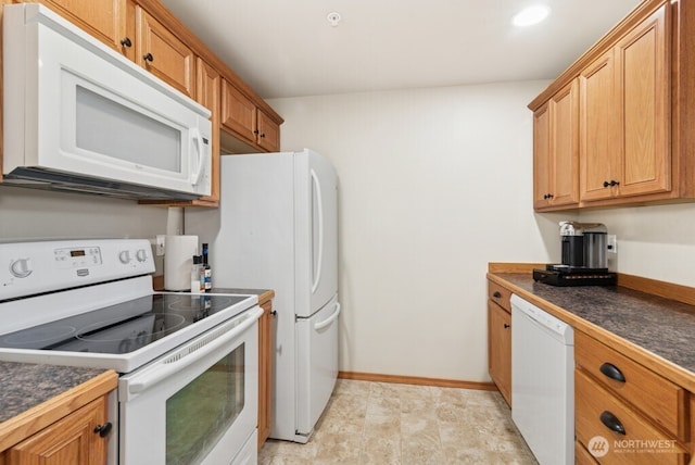 kitchen featuring white appliances, dark countertops, brown cabinets, and baseboards