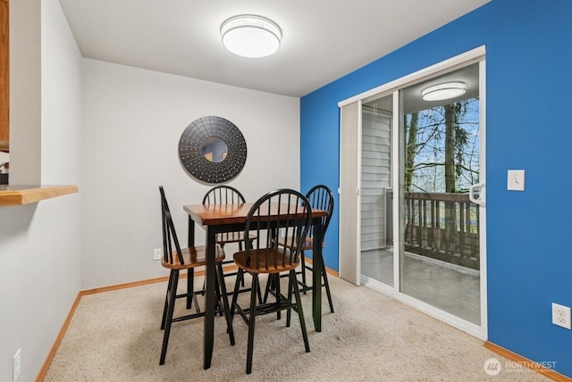 carpeted dining space with baseboards