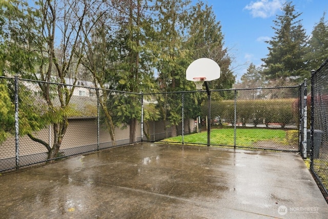 view of basketball court featuring community basketball court, fence, and a gate