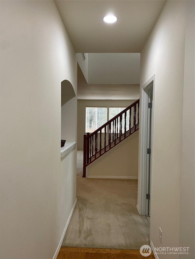 corridor with stairs, carpet, and baseboards