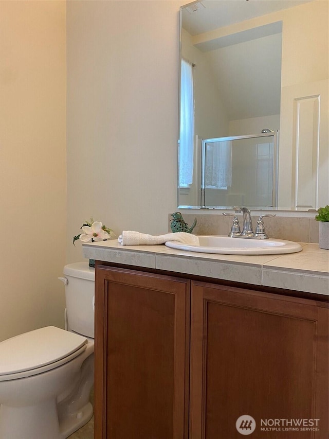 bathroom with toilet, a shower stall, and vanity