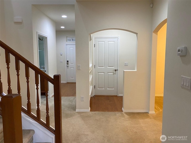 hall featuring baseboards, stairway, recessed lighting, and light colored carpet