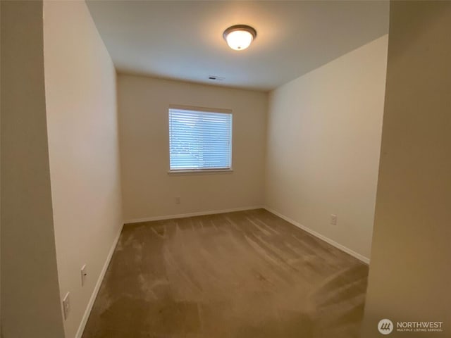 carpeted spare room featuring visible vents and baseboards