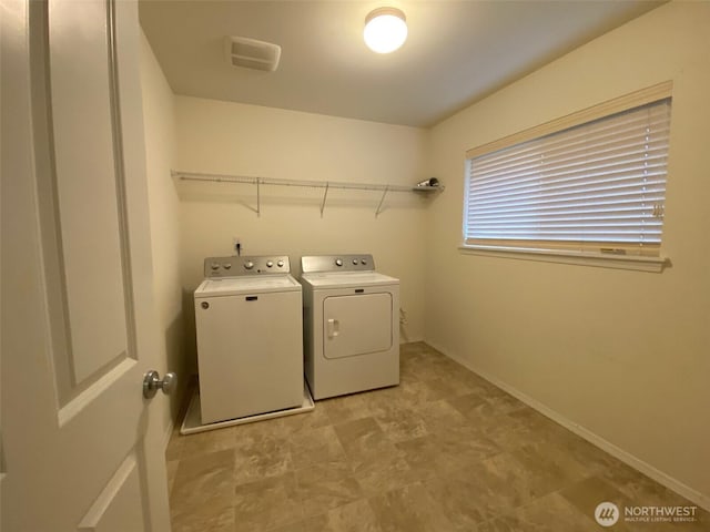 clothes washing area with laundry area, washer and clothes dryer, and baseboards