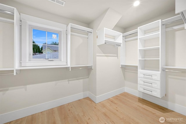 walk in closet with visible vents and wood finished floors