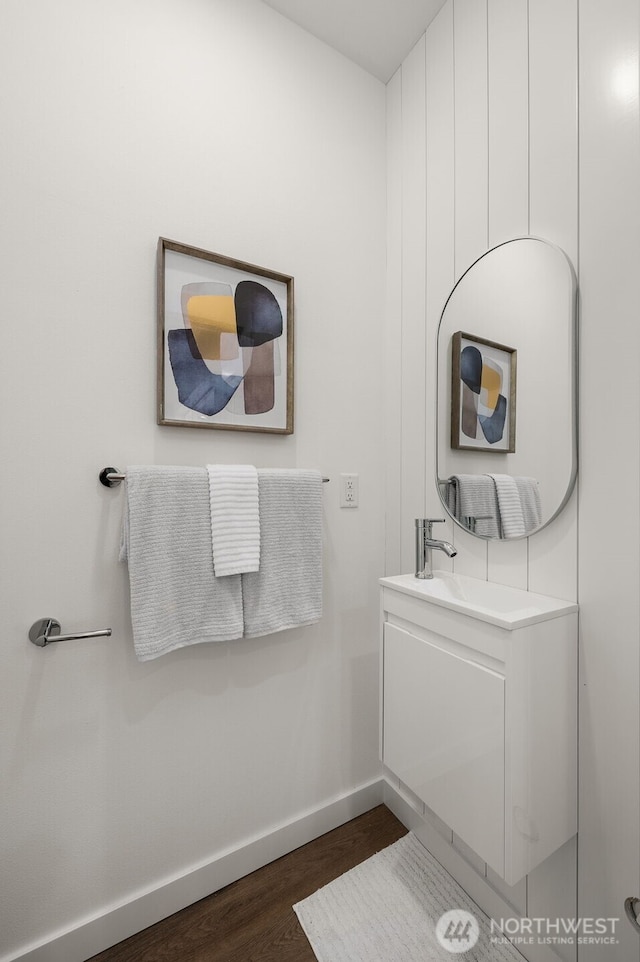 bathroom with baseboards, wood finished floors, and vanity