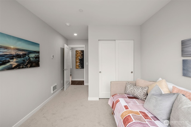 living area with baseboards, visible vents, and light colored carpet