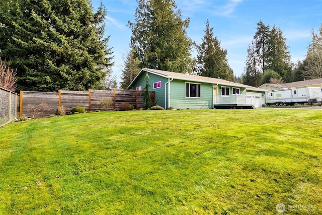 exterior space with a lawn, an attached garage, and fence