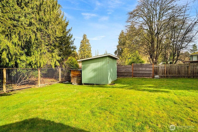 view of yard with a shed, an outdoor structure, and a fenced backyard