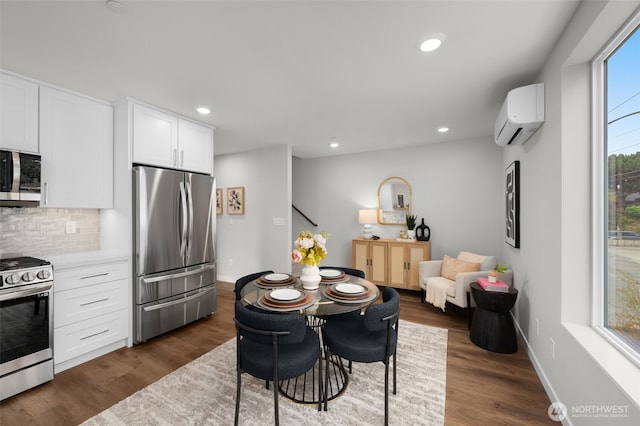 kitchen with decorative backsplash, appliances with stainless steel finishes, light countertops, white cabinetry, and a wall mounted AC