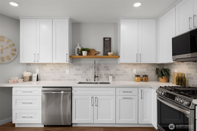 kitchen featuring appliances with stainless steel finishes, a sink, and white cabinets