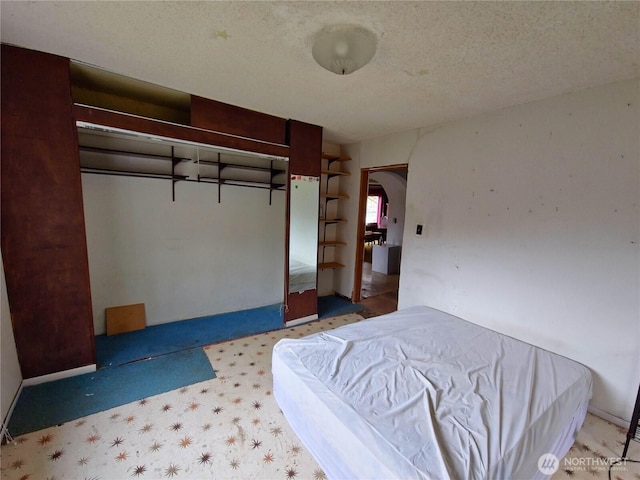 unfurnished bedroom with arched walkways, carpet flooring, a textured ceiling, and baseboards