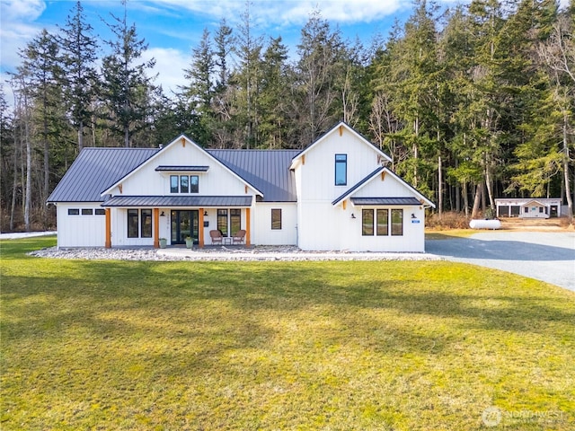 modern inspired farmhouse with metal roof, a porch, a standing seam roof, and a front yard