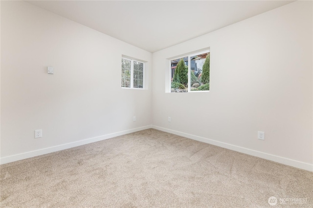 carpeted empty room featuring baseboards