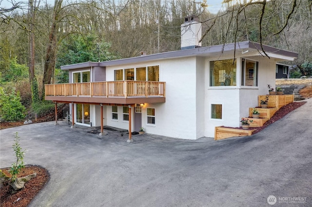 exterior space with stucco siding and a chimney