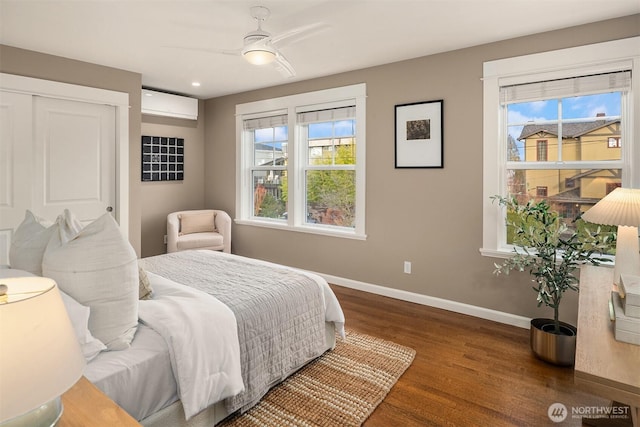 2311 42nd Ave E, Seattle, WA 98112 - bedroom featuring a wall unit AC, multiple windows, wood finished floors, and baseboards