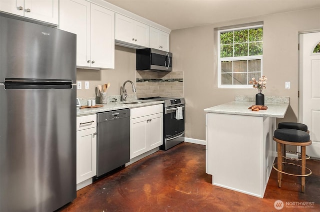2311 42nd Ave E, Seattle, WA 98112 - kitchen featuring a kitchen bar, a sink, white cabinetry, appliances with stainless steel finishes, and decorative backsplash
