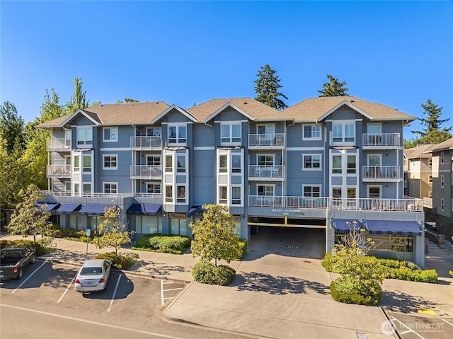 view of property with uncovered parking and a residential view