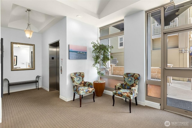 sitting room featuring carpet, a tray ceiling, lofted ceiling, elevator, and baseboards