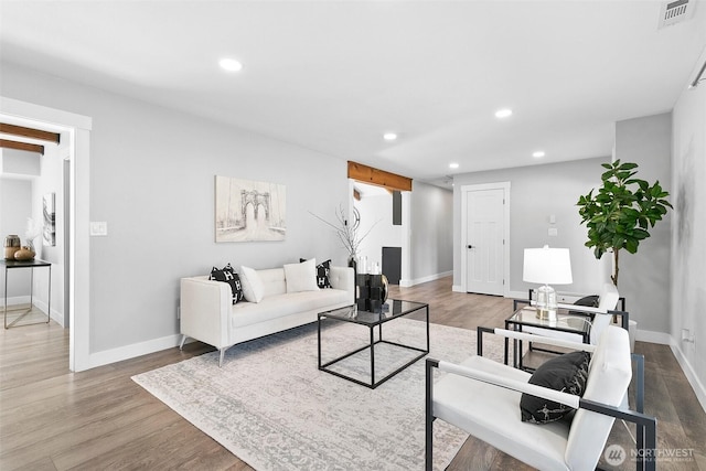 living room with baseboards, wood finished floors, visible vents, and recessed lighting