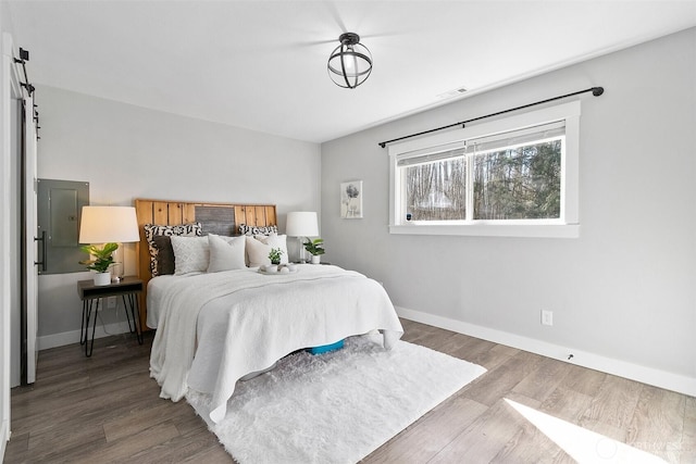 bedroom featuring visible vents, baseboards, and wood finished floors