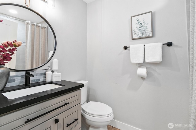 full bathroom with toilet, curtained shower, baseboards, and vanity