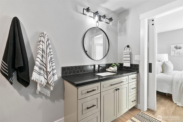 bathroom featuring ensuite bathroom, wood finished floors, and vanity