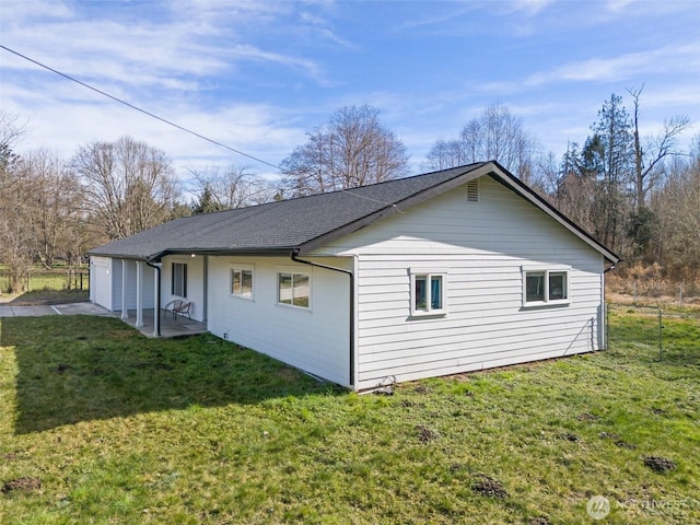 view of property exterior with fence, a patio, and a yard