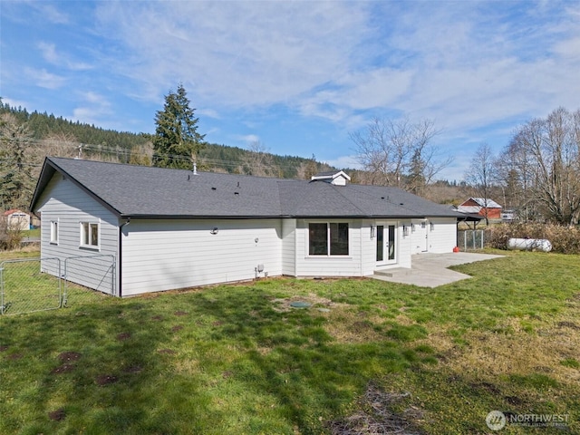 back of property featuring a patio area, a lawn, and fence