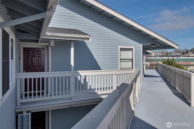 exterior space featuring roof with shingles and a balcony