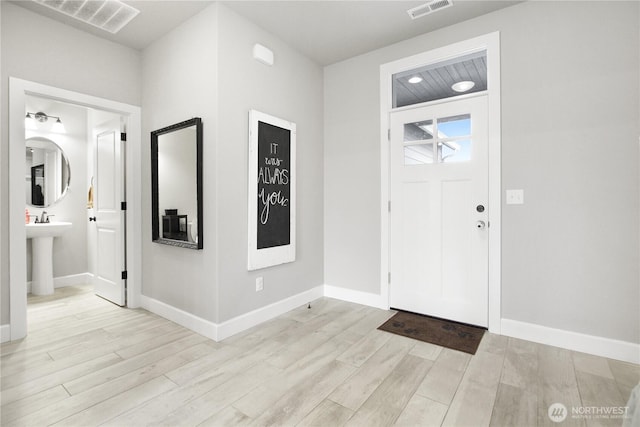 entrance foyer featuring light wood-type flooring, visible vents, and baseboards