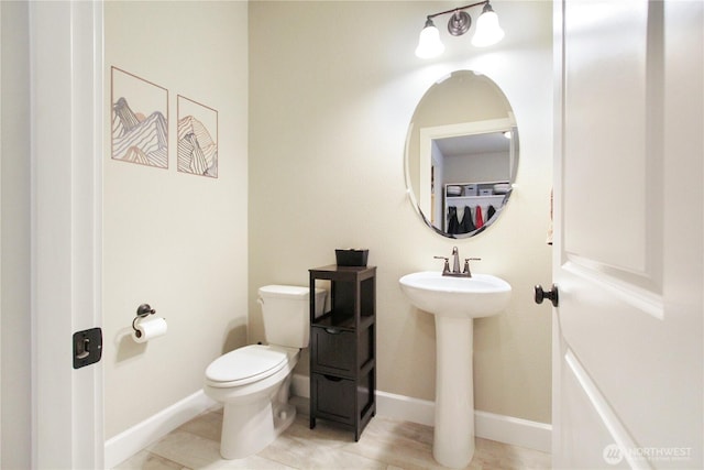 bathroom with baseboards, a sink, and toilet