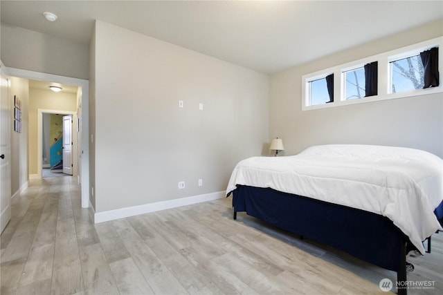 bedroom with light wood-style flooring and baseboards