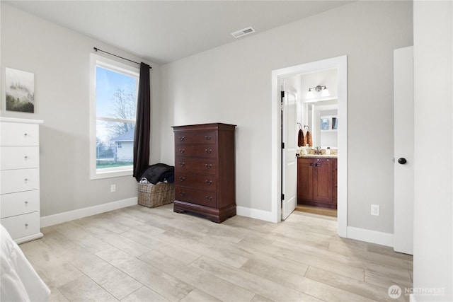 bedroom with baseboards, visible vents, and light wood-style floors