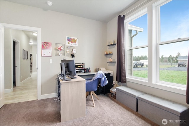 office featuring baseboards and light colored carpet