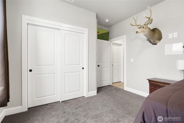 bedroom featuring a closet, light carpet, and baseboards