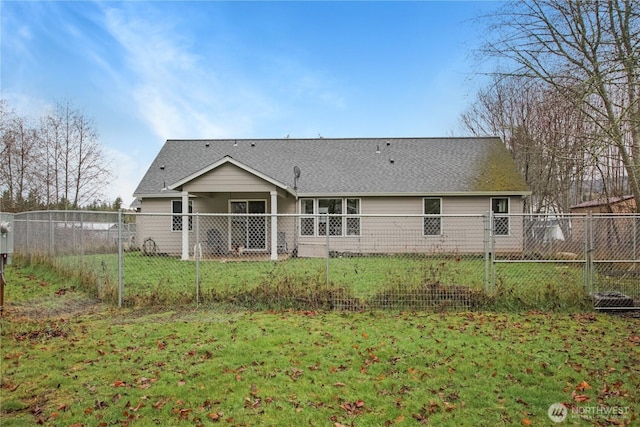 rear view of property featuring roof with shingles, a lawn, and fence private yard