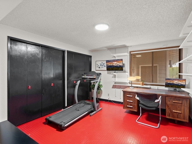 workout area with baseboards and a textured ceiling