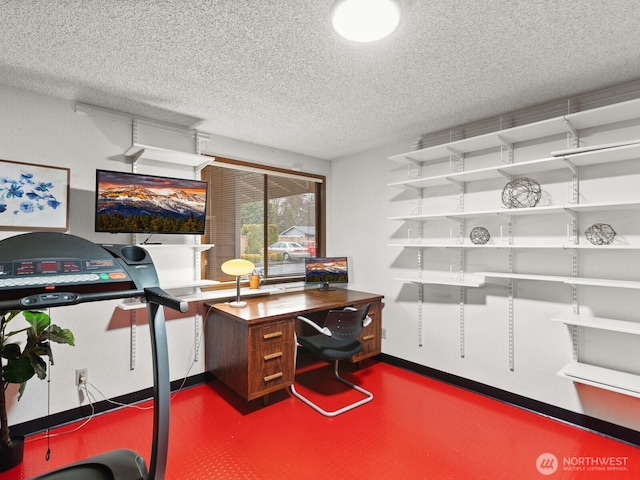 office area with concrete floors, baseboards, and a textured ceiling