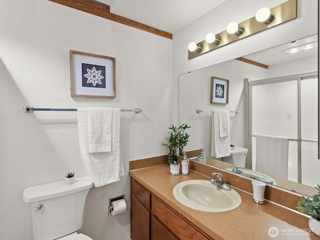 full bath with a stall shower, vanity, and toilet