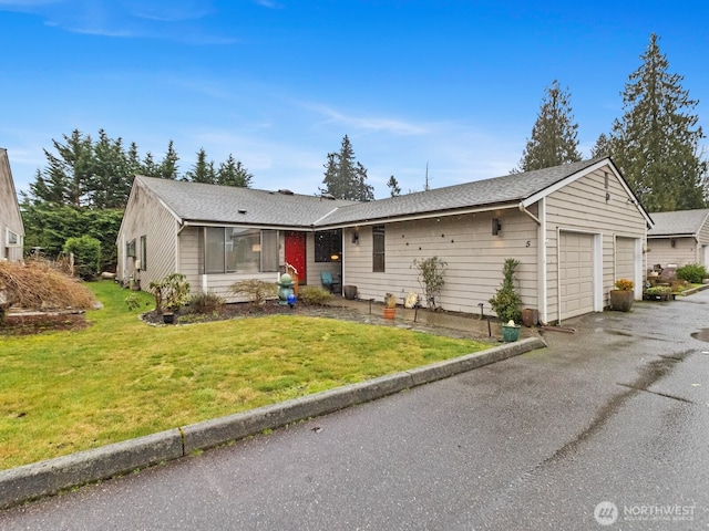 ranch-style home featuring a front lawn and an attached garage