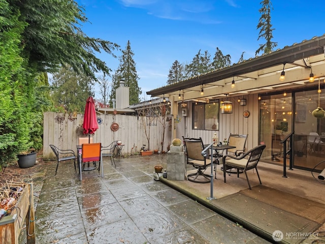 view of patio with outdoor dining space and fence