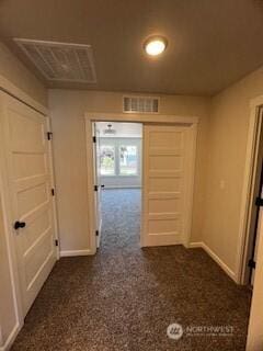 hallway featuring baseboards and visible vents