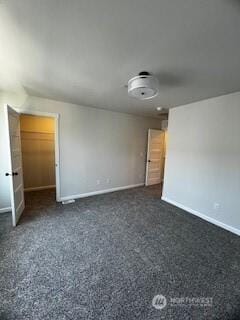 empty room with baseboards and dark speckled floor