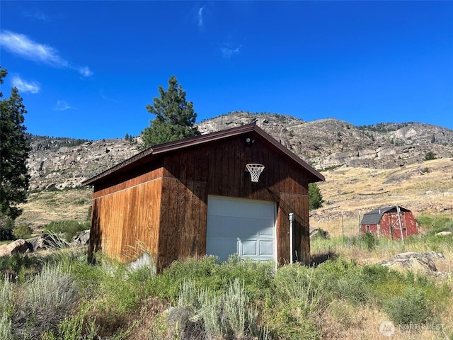 view of outdoor structure with a mountain view and an outbuilding