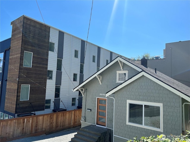 back of house featuring entry steps and fence