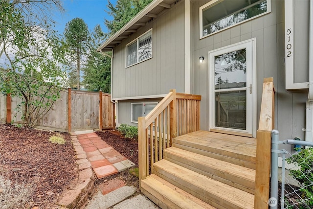 view of exterior entry featuring fence