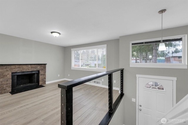 stairway with baseboards, a fireplace, and wood finished floors