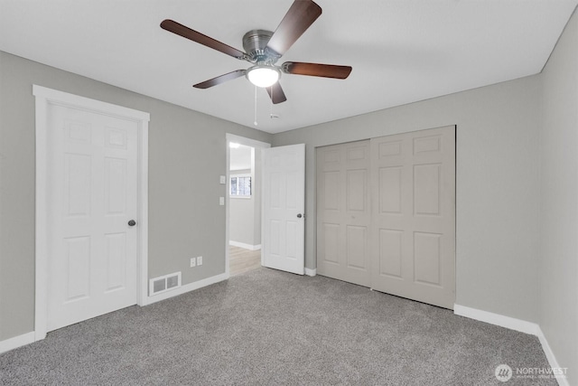 unfurnished bedroom with carpet flooring, a closet, baseboards, and visible vents